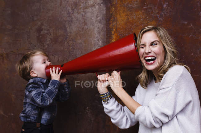 Junge spricht in Megafon, Frau hält Megafon ans Ohr — Stockfoto