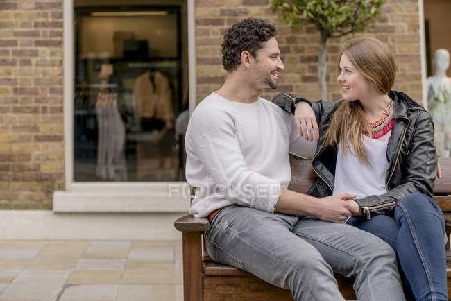 Romântico jovem casal sentado no banco, Kings Road, Londres, Reino Unido — Fotografia de Stock