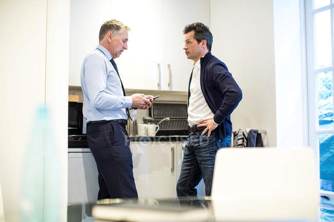 Colleagues in office kitchen having discussion — Stock Photo