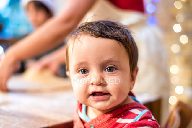 Portrait of baby boy, family in background — Stock Photo