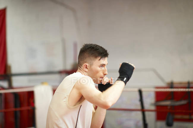 Боксер, практикующий в боксерском ринге — стоковое фото