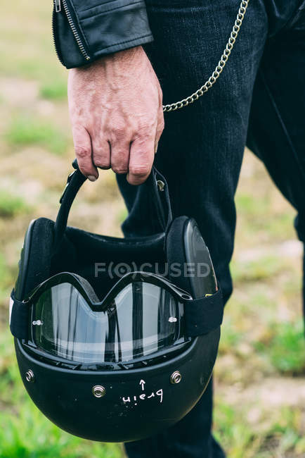 Hand of male motorcyclist holding black crash helmet — Stock Photo