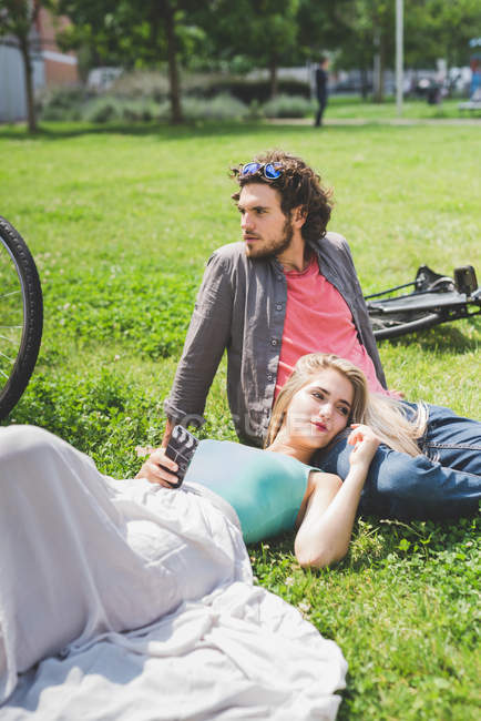 Coppia rilassante nel parco sull'erba insieme — Foto stock