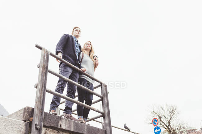 Low angle view of young couple looking out from harbour wall, Lake Como, Italy — Stock Photo
