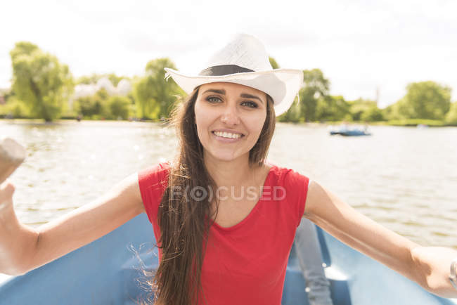 Felice giovane donna a remi una barca nel parco — Foto stock