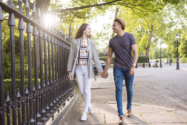 Young couple walking in street holding hands — Stock Photo