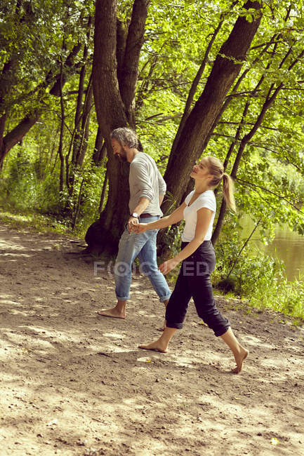 Couple main dans la main au bord de la rivière — Photo de stock