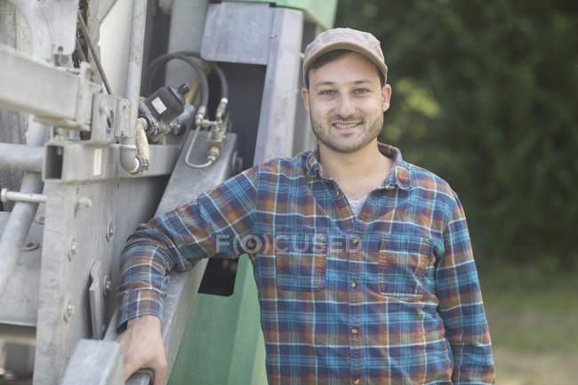 Portrait of man leaning against truck looking at camera smiling — Stock Photo