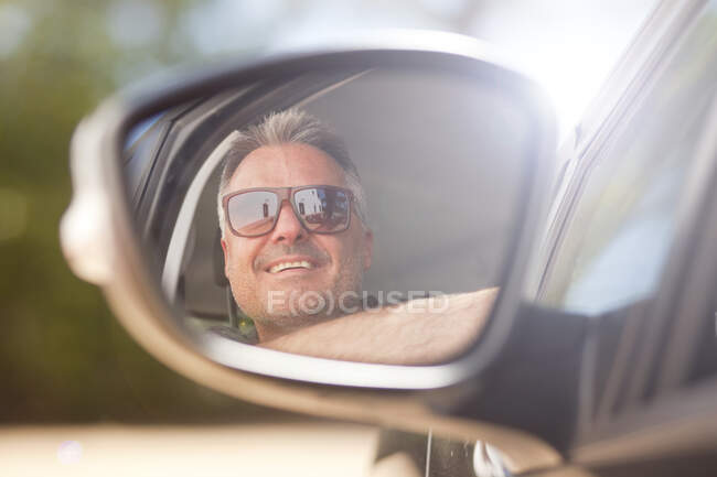 Homme regardant par la fenêtre de la voiture — Photo de stock