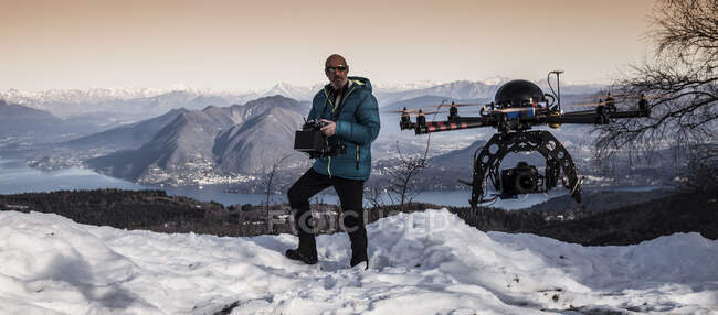 Mature man preparing to fly drone, Stresa, Piedmont, Italy — Stock Photo