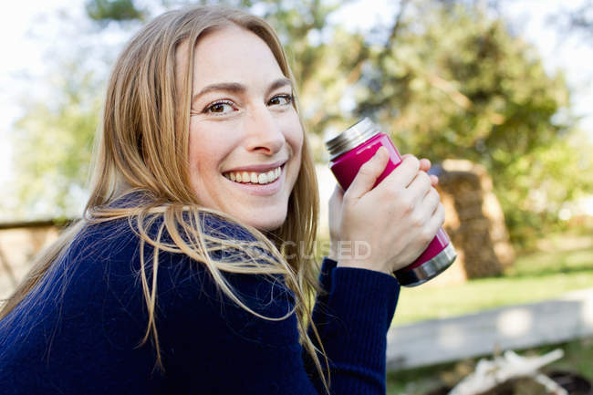 Mid adult woman drinking hot drink — Stock Photo