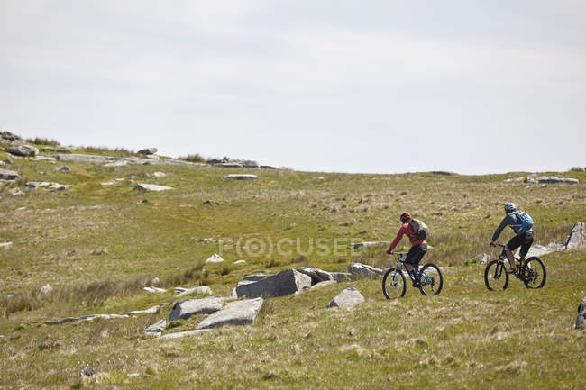 Ciclistas de ciclismo na encosta rochosa — Fotografia de Stock