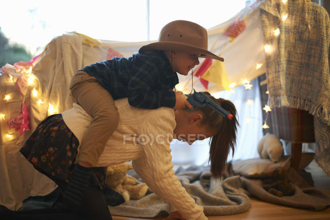 Junge im Cowboy-Hut bekommt Huckepack-Fahrt von Schwester — Stockfoto