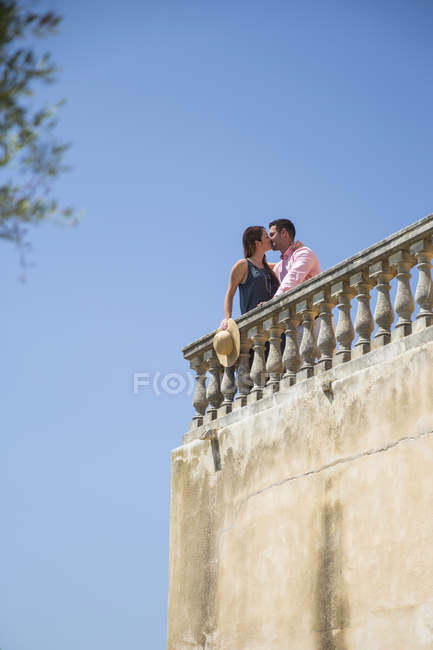 Couple embrassant sur le balcon sur le toit du boutique hôtel, Majorque, Espagne — Photo de stock