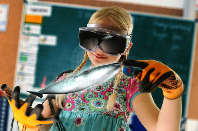 Girl pretending to be teacher wearing virtual reality headset and gloves to show whale — Stock Photo