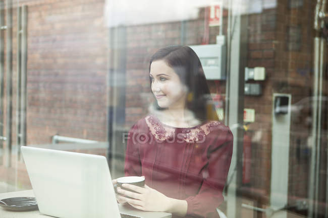 Businesswoman working with laptop in cafe — Stock Photo