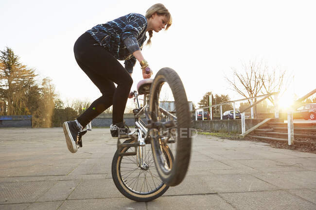 Feminino BMX piloto fazendo BMX truque no parque — Fotografia de Stock
