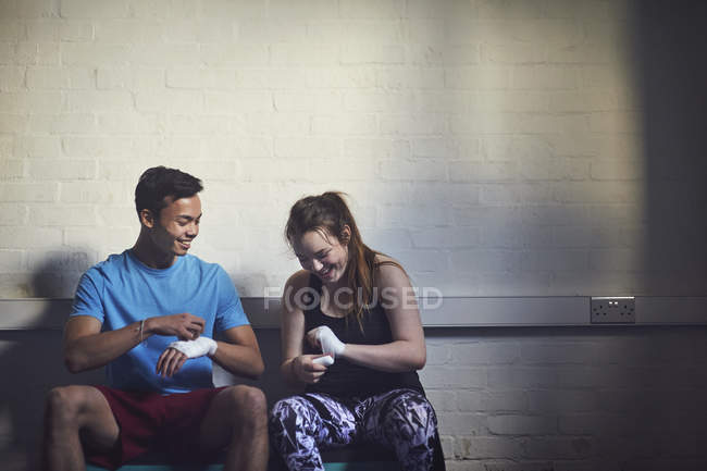 Young male and female boxers wrapping hands in bandages — Stock Photo