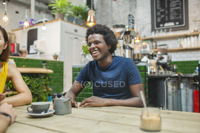 Mulher e homens amigos conversando juntos no café — Fotografia de Stock