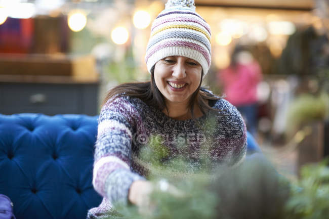 Mulher madura usando chapéu de malha bebendo vinho tinto no café da calçada — Fotografia de Stock