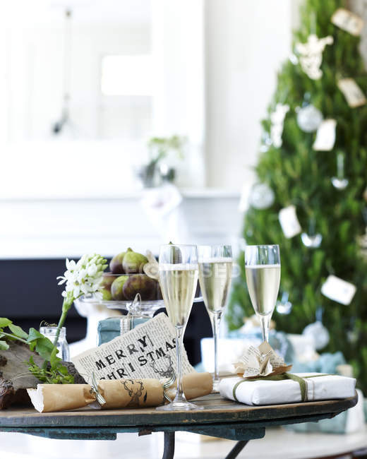 Tavola di champagne con cracker natalizi e regali — Foto stock