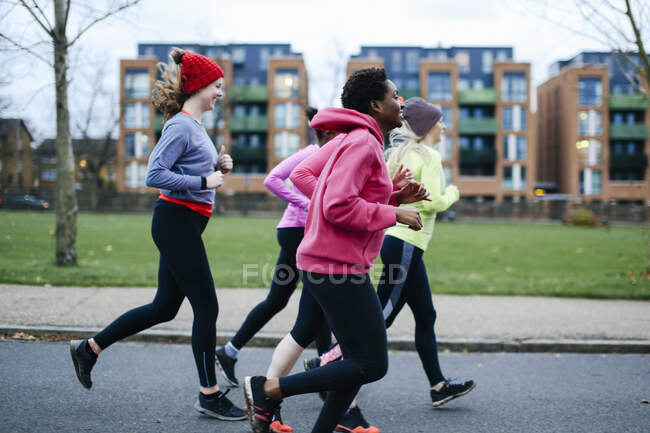 Cinco corredoras corriendo por la acera de la ciudad - foto de stock