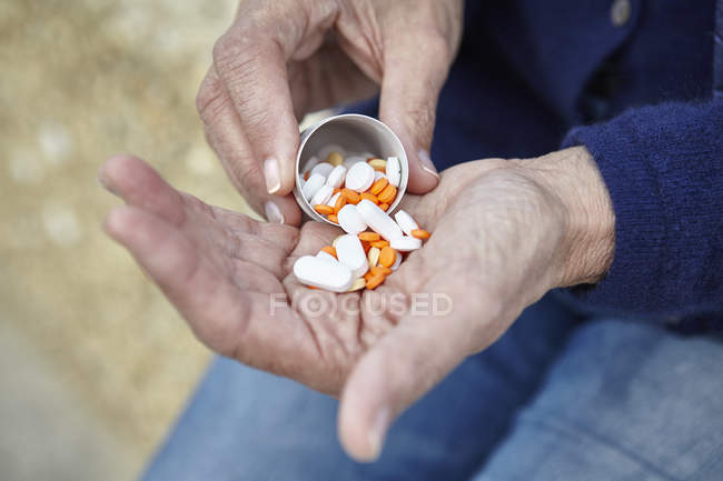 Mulher dispensando pílulas de garrafa pílula na mão — Fotografia de Stock