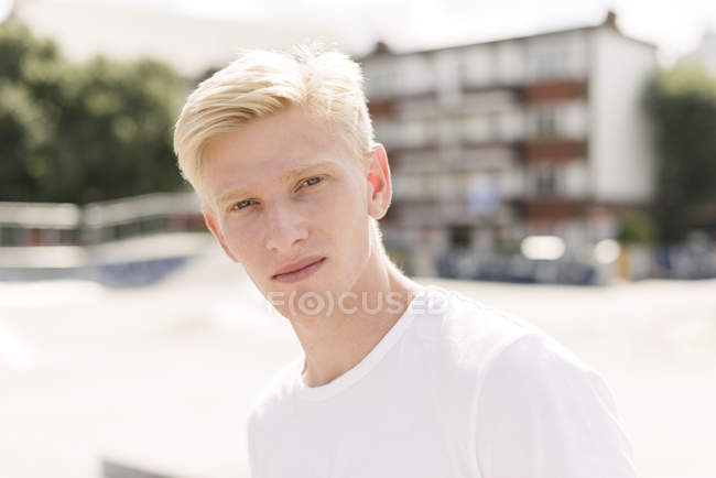Retrato de loiro jovem skatista masculino no parque de skate — Fotografia de Stock