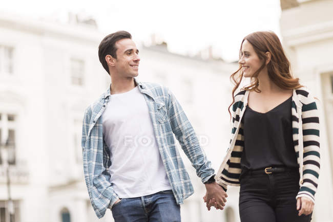 Casal andando na rua cara a cara sorrindo — Fotografia de Stock