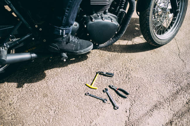Colpo ritagliato di piede motociclisti maschi e strumenti su strada — Foto stock