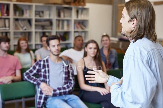 Lecturer lecturing group of students in higher education college classroom — Stock Photo
