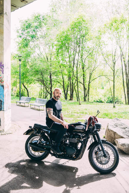 Retrato de um motociclista maduro sentado em moto — Fotografia de Stock