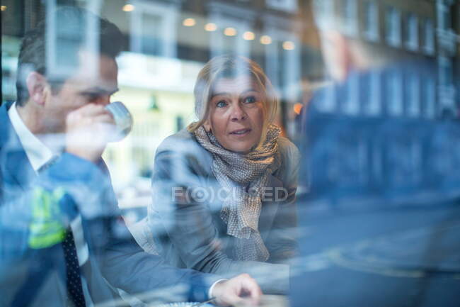 Businessmen and woman having working lunch in restaurant — Stock Photo