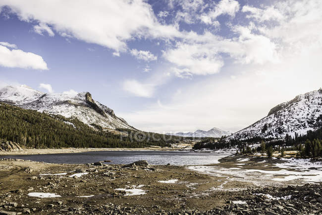 Vista del lago y las montañas nevadas a la luz del sol - foto de stock