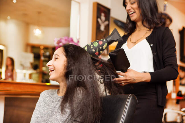 Перукарня і дівчина сміються під час сухого удару в перукарні — стокове фото