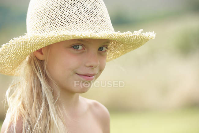 Portrait de jeune fille à l'extérieur, portant un chapeau de paille — Photo de stock