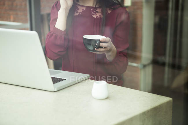 Donna d'affari che lavora con il computer portatile in caffè — Foto stock