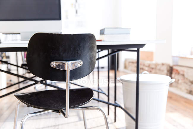 Schreibtisch und Stühle und Mülleimer im Büroinnenraum — Stockfoto
