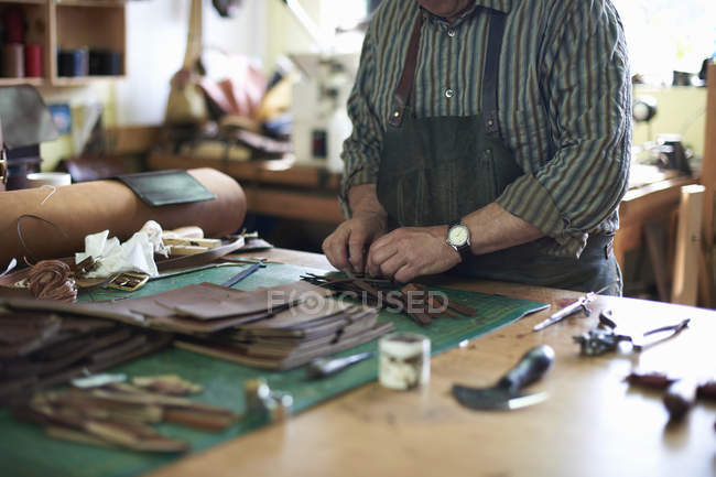 Trabalhador masculino na oficina de couro, organizando couro, seção meados — Fotografia de Stock