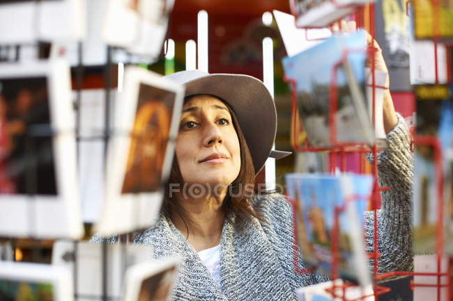 Frau schaut sich Postkarten im Geschäft an — Stockfoto
