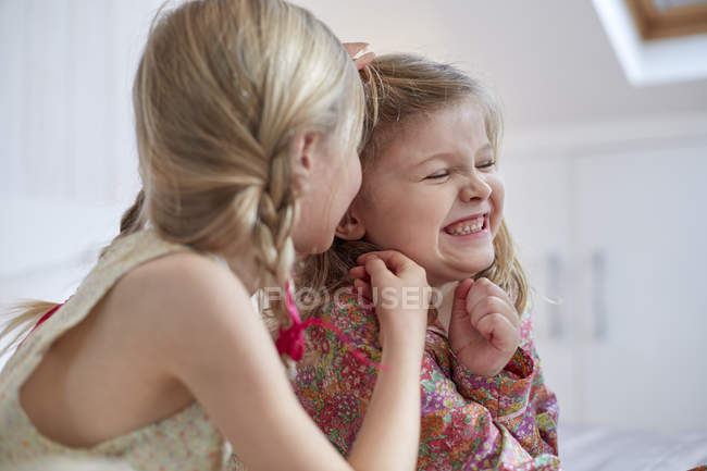 Girls sharing secret in loft room — Stock Photo