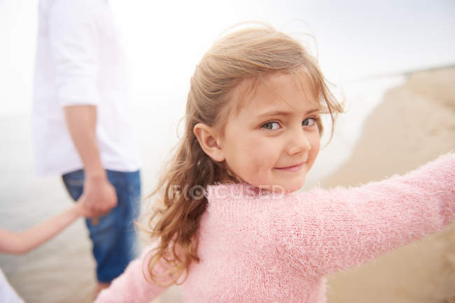 Famiglia che cammina sulla spiaggia, figlia che guarda oltre le spalle — Foto stock