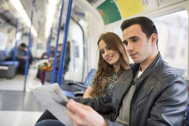 Пара на поїзд, читаючи газету — стокове фото