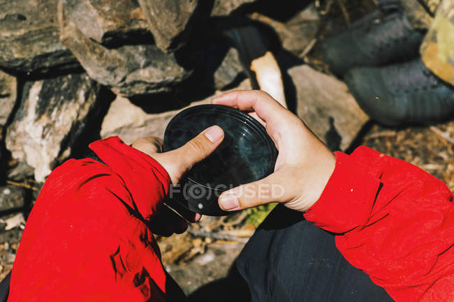 Cropped image of male hiker holding cup of tea — Stock Photo