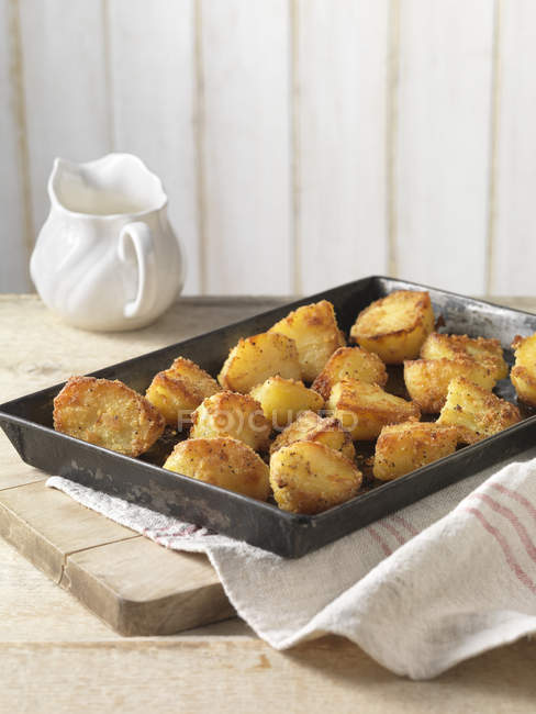 Roasted potatoes with crispy seasoning in tray — Stock Photo