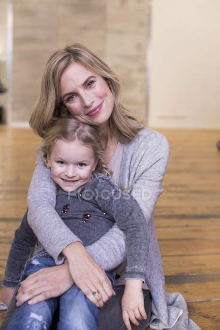 Ritratto di madre e figlia, seduta sul pavimento, sorridente — Foto stock