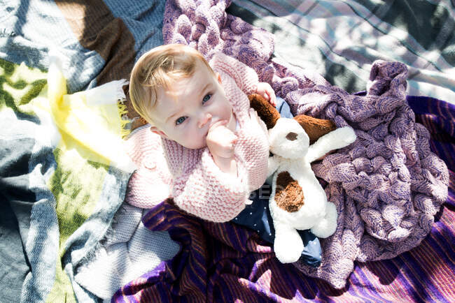 Ritratto sopraelevato della bambina che alza lo sguardo dalla coperta in giardino — Foto stock