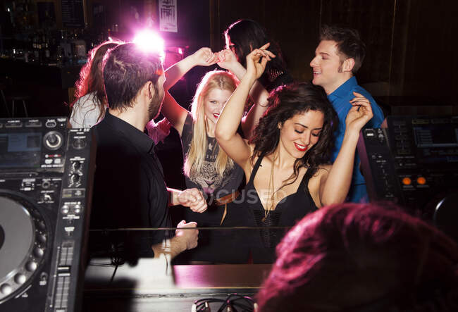 Group of friends dancing in front of  DJ in nightclub — Stock Photo