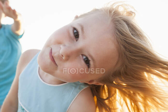Portrait of girl, head cocked, looking at camera smiling — Stock Photo