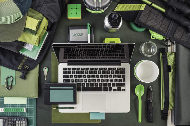 Top view of laptop, external hard drive and hiking equipment, green — Stock Photo